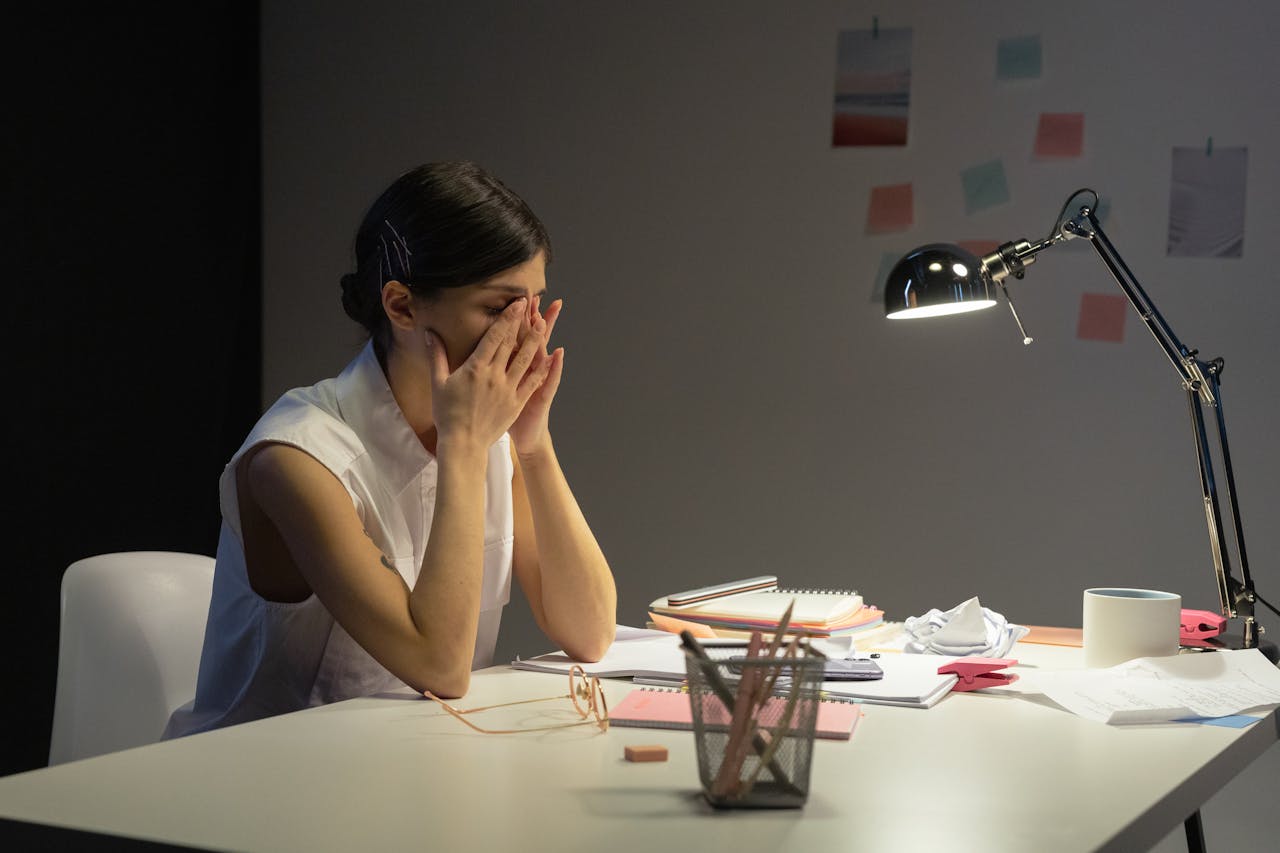 Stressed professional woman overwhelmed at work, highlighting mental fatigue and pressure.