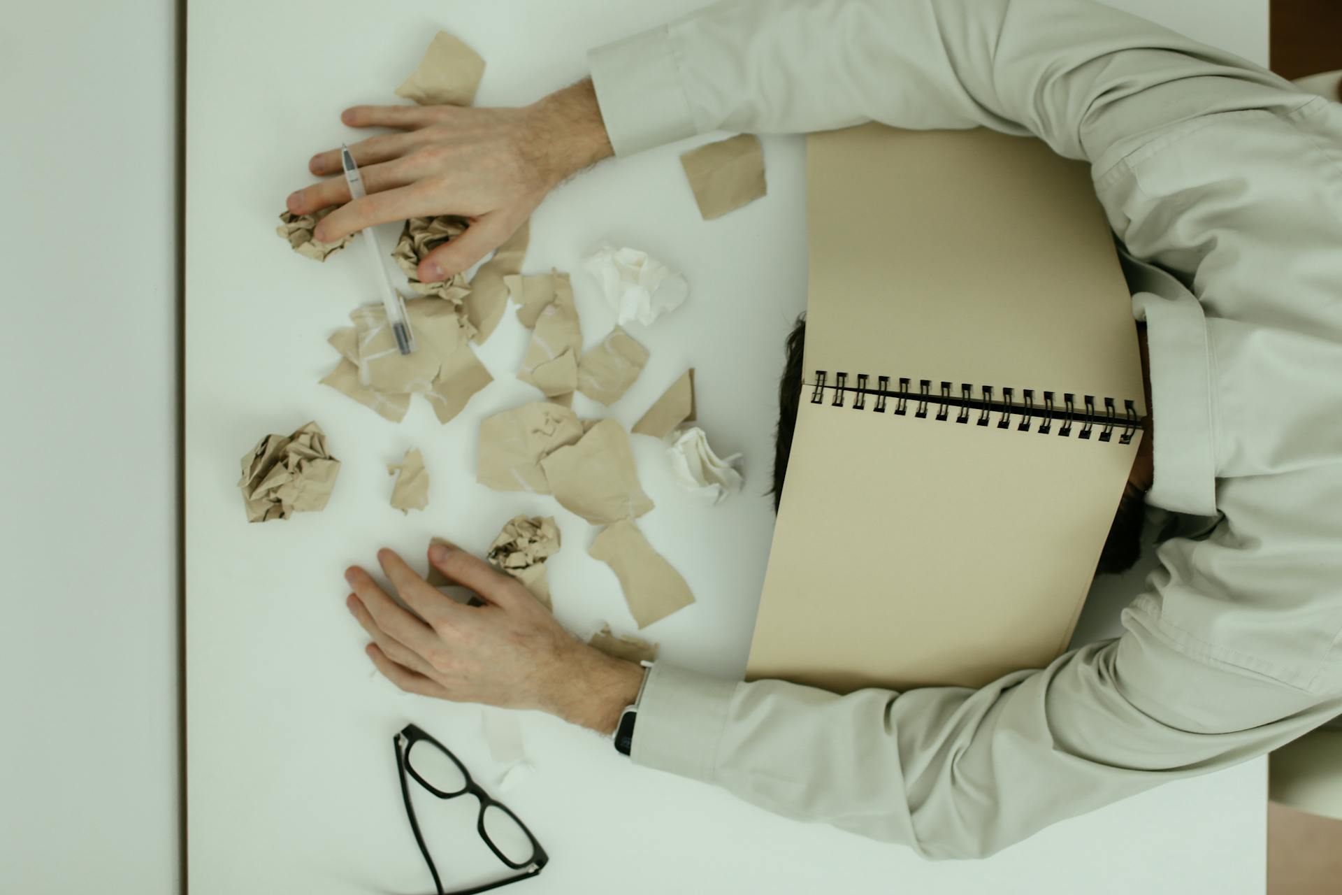 Exhausted employee asleep at a cluttered desk after long work hours, capturing the emotional and physical effects of workplace burnout.
