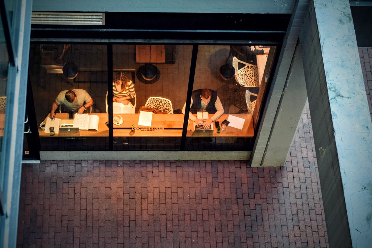 Team of professionals working late at night around a conference table in a modern office workspace