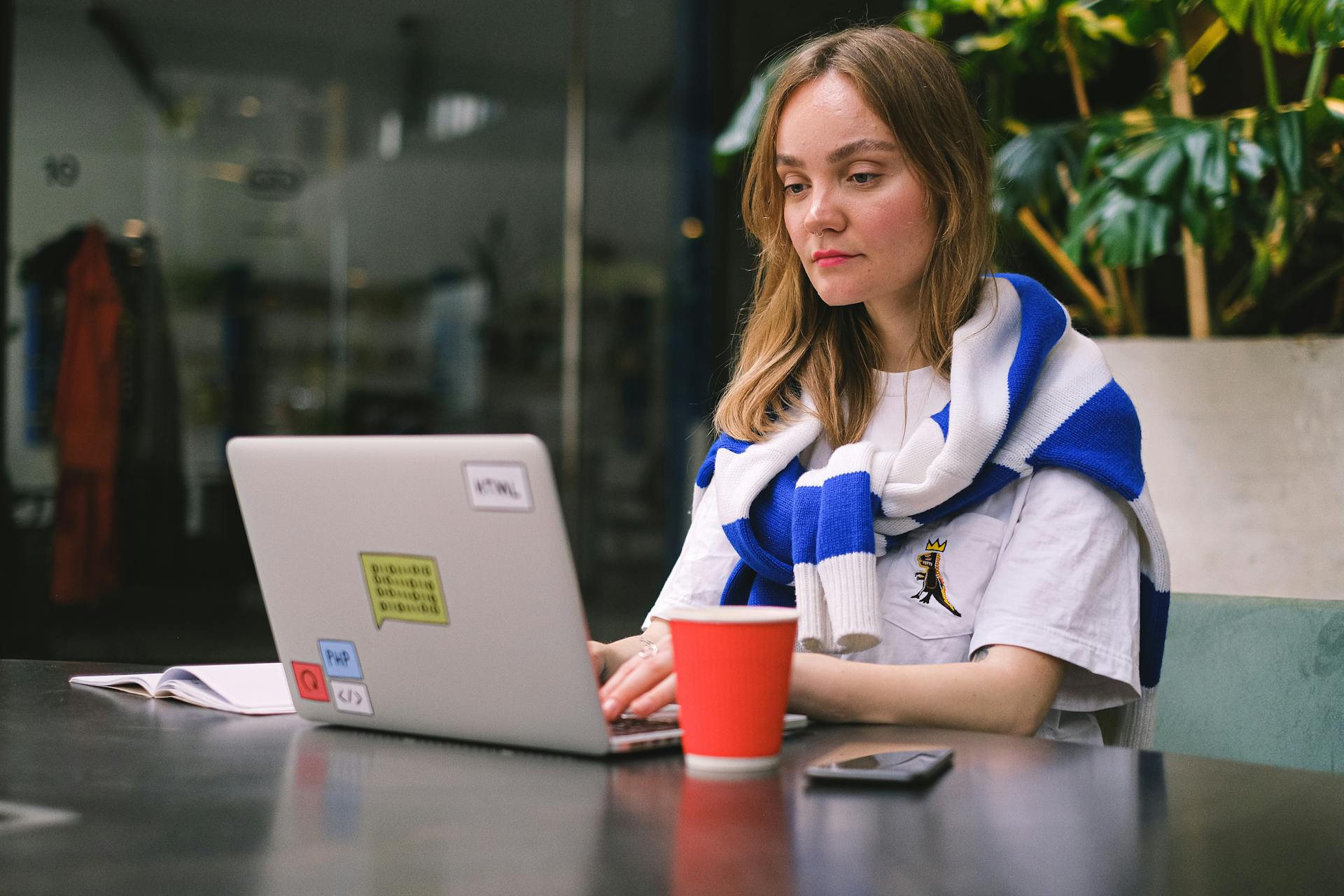 Woman doing deep work alone on laptop in a quiet indoor workspace.